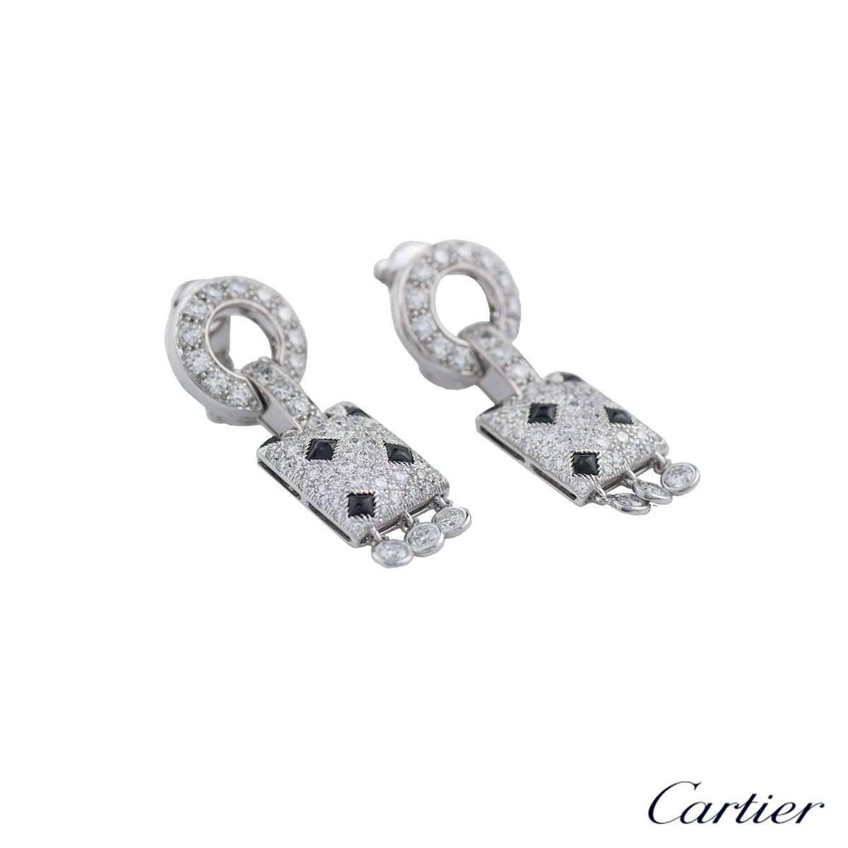 A stunning pair of 18k white gold earrings from the Panthere de Cartier collection. The earrings feature a diamond set circular motif with a bar link connecting to a rectangular diamond and onyx set panel, suspending three freely moving diamonds.