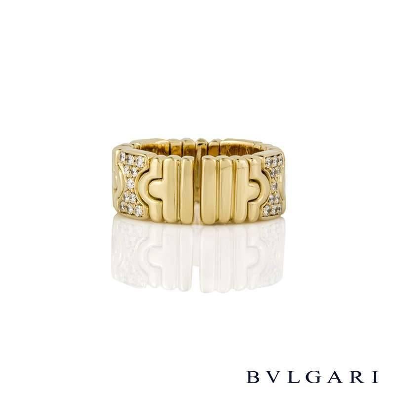 An 18k yellow gold diamond set ring from the Parentesi collection by Bvlgari. The band is comprised of alternating plain and diamond set geometrical design intersections, with the diamond weight totalling approximately 0.44ct. The 7mm band is