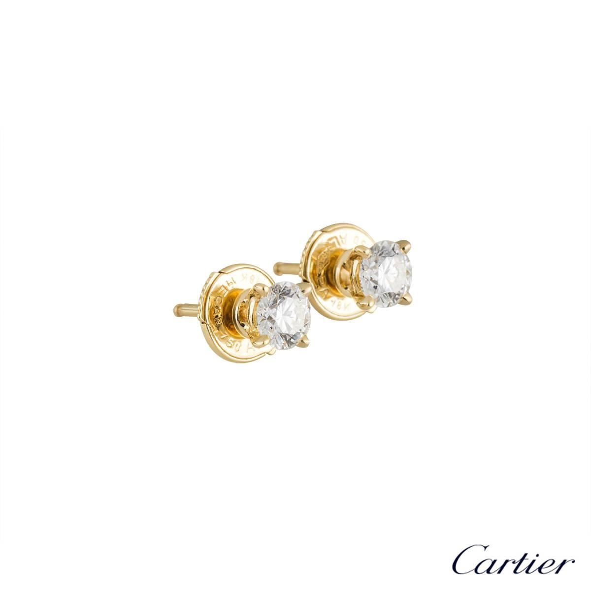 An elegant pair of diamond earrings from the 1895 collection by Cartier. Each earring has a single caw set round brilliant cut diamond, set in 18k yellow gold. The first diamond weighs 0.26ct, is E colour and VS1 in clarity and the second weighs