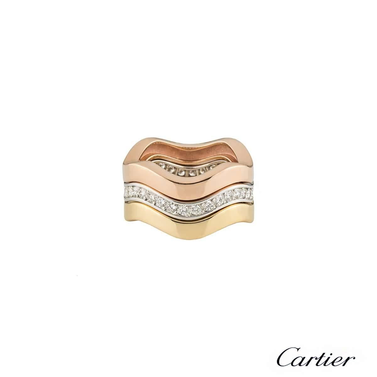 A beautiful 18k tri-colour gold Trinity stacker ring by Cartier. The ring is composed of 3 waved bands, each in yellow, rose and white gold. The white gold band is pave set with 34 round brilliant cut diamonds totalling approximately 1.02ct,
