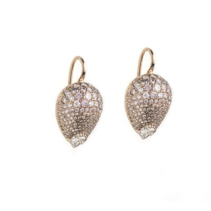 A pair of diamond set drop earrings in 18k rose gold. The pear shape earrings have multiple pave set diamonds varying in size across the main body of the earring and a pear cut diamond to finish at the bottom, both earrings have a total diamond