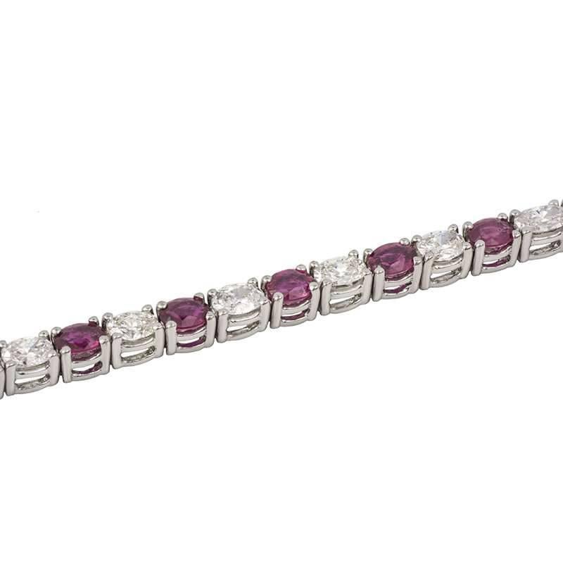 A stunning 18k white gold ruby and diamond line bracelet. The bracelet is composed of 20 oval cut Burmese rubies totalling 4.29ct each dispersing a vibrant red hue throughout, alternating between 20 oval cut diamonds weighing 3.41ct, predominantly