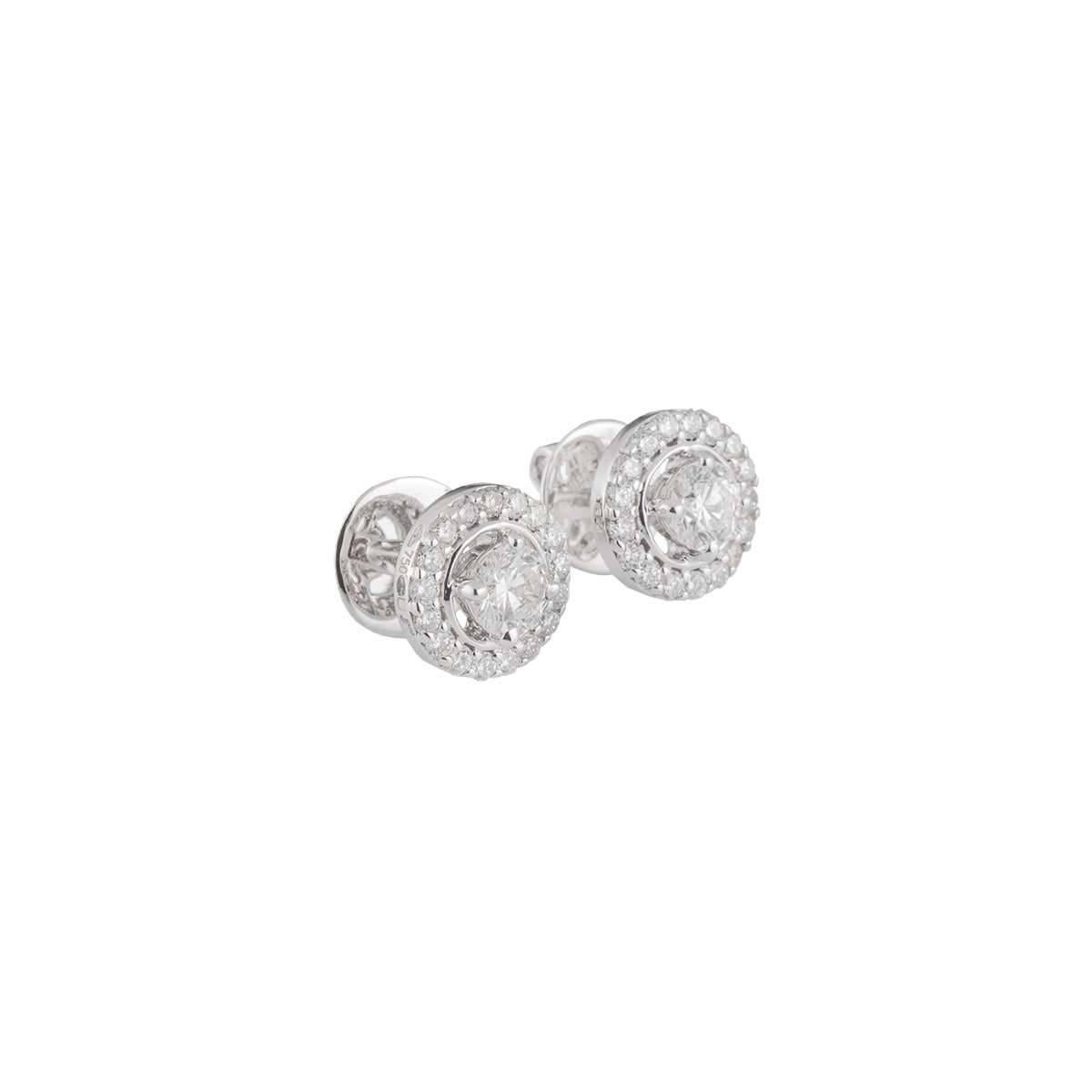 A beautiful pair of 18k white gold diamond earrings. The earrings have a round brilliant cut diamond single solitaire 0.84ct with a halo of 17 diamonds totalling approximately 0.55ct all with colour H-I and VS-SI clarity. The earrings have a gross