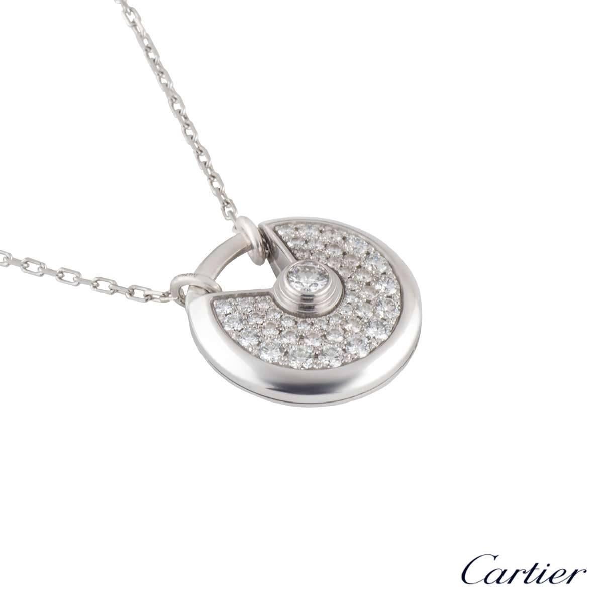 A stunning 18k white gold diamond set Amulette de Cartier pendant. The circular talisman motif has a single round brilliant cut rubover set diamond in the centre weighing 0.15ct, surrounded by a further 42 pave set round brilliant cut diamonds