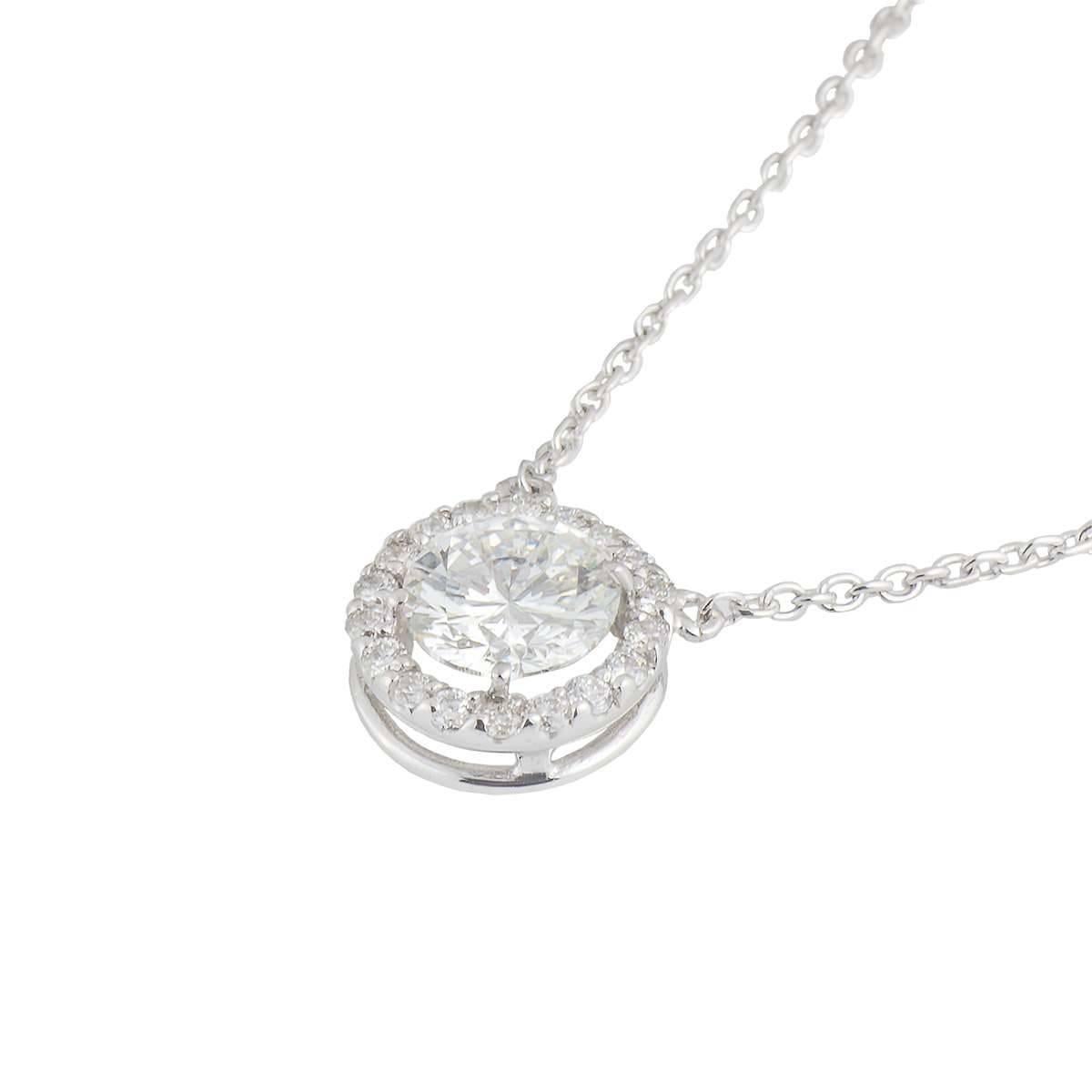 An 18k white gold round brilliant cut diamond pendant. The pendant is set to the centre with a round brilliant cut diamond weighing approximately 0.70ct, G colour and VS in clarity. Complementing the central stone is a halo of 18 round brilliant cut
