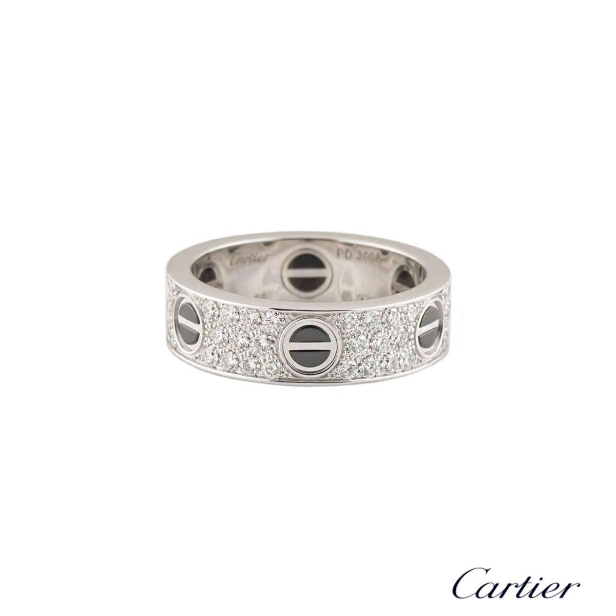 An 18k white gold diamond set Love ring by Cartier. The ring features the classic screw motif, featuring a ceramic inlay, around the outer edge and has 66 pave set, round brilliant cut diamonds set between each screw, totalling 0.74ct. The ring is a