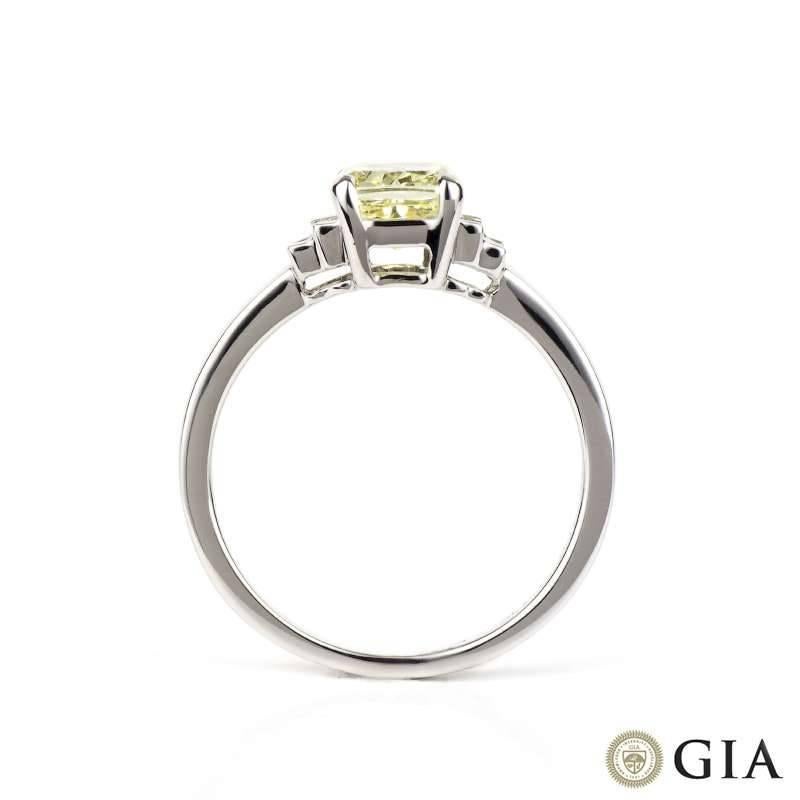 A stunning fancy yellow cushion cut diamond ring with white diamond set shoulders. The ring is centred with a 1.03ct natural fancy yellow cushion cut diamond. Set to the shoulders are four baguette cut diamonds totalling 0.10ct, the diamonds are G