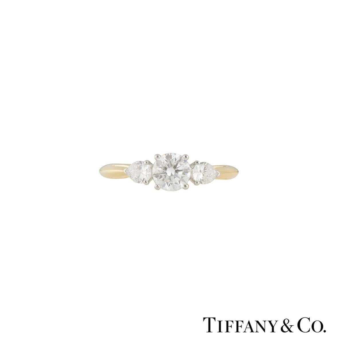 A beautiful 18k yellow gold Tiffany & Co. diamond ring from the Three Stone collection. The ring comprises of a round brilliant cut diamond in a 4 claw platinum setting with a total weight of 0.93ct, G colour and VS clarity. Complimenting the centre