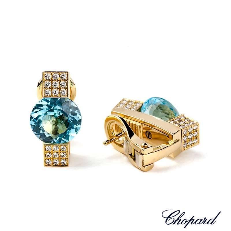 A pair of 18k yellow gold earclips fom Chopard. The earrings have 72 diamonds in total weighing 0.72ct and 2 round faceted topaz stones weighing 7.00ct. The earrings are approximately 1.8cm in length and have a gross weight of 14.89 grams. 
The