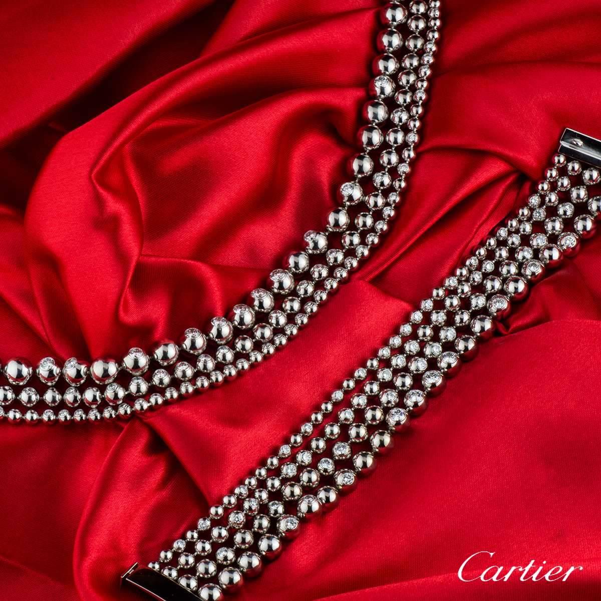 A luxurious 18k white gold Cartier diamond jewellery suite from the Moonlight collection. The jewellery consists of a necklace and bracelet. The necklace comprises of 3 strands featuring 196 circular ball motifs assymetrically set round brilliant