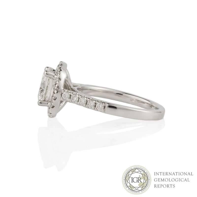 An 18k white gold diamond ring. The central round brilliant cut diamond weighs 2.00ct, is G colour and VVS1 in clarity, set within a classic four claw setting. Accentuating the diamond is a round brilliant cut diamond halo and half diamond set