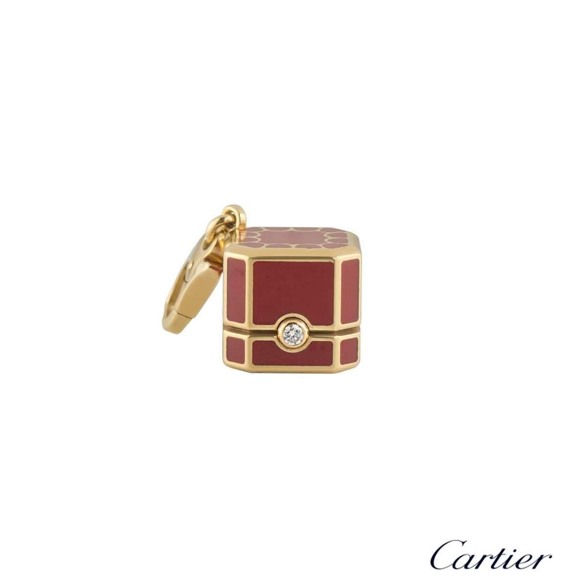 A unique red box charm by Cartier. The charm is a miniature Cartier presentation box with a red lacquer coating and yellow gold detailing. The charm has a single round brilliant cut diamond weighing approximately 0.03ct. The charm is 2.5cm in