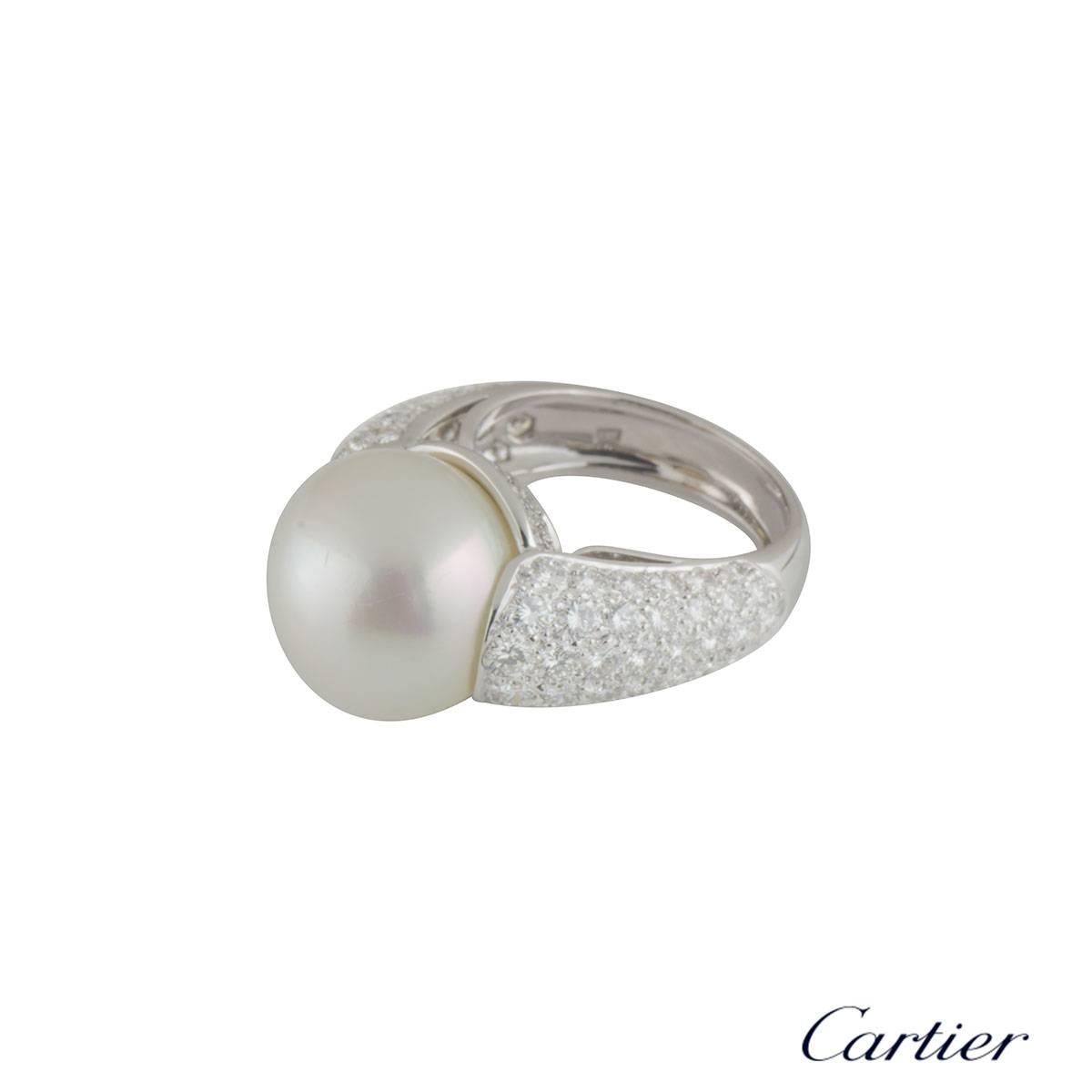 A beautiful 18k white gold Cartier pearl and diamond dress ring. The ring comprises of a pearl set to the centre measuring approximately 14mm in diameter. Complementing the pearl are 110 round brilliant cut diamonds in a pave setting down the
