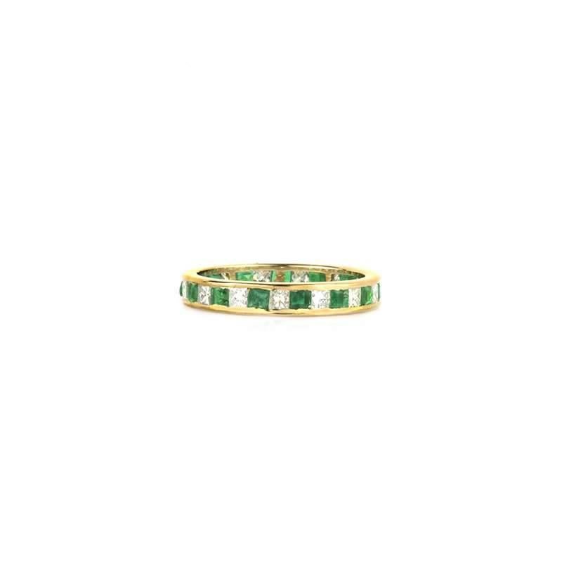 An 18k yellow gold emerald and diamond full eternity ring. The ring is made up of 15 princess cut emeralds totalling 1.12ct alternating with 15 princess cut diamonds weighing 0.81ct, colour H and VS/SI clarity. The ring is a size N 1/2, US 6 3/4 and