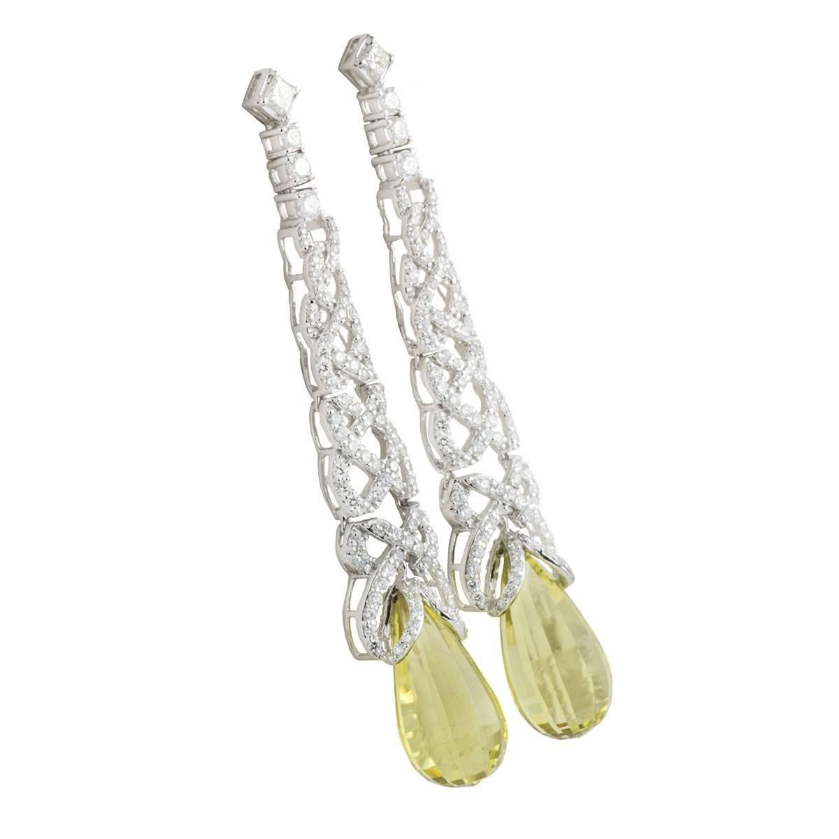 A sparkly 18k white gold diamond and lemon quartz drop earrings. The earrings comprise of an intricate open work design with 207 round brilliant cut diamonds in a pave set, with a total weight of 3.42ct, G-H colour and VS clarity. Each earring is