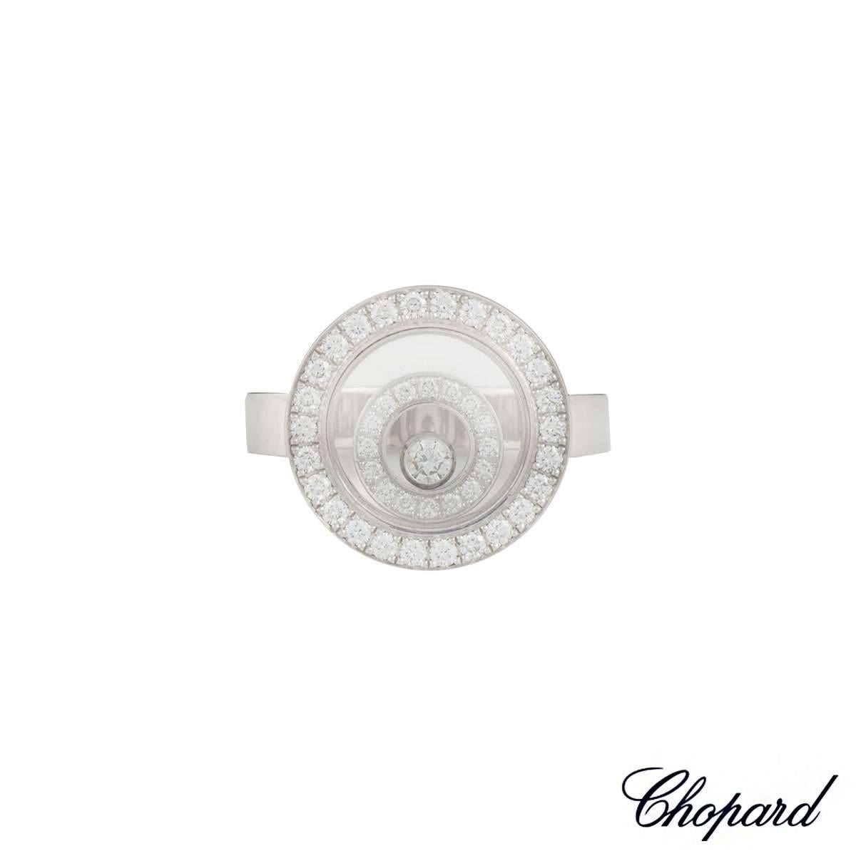 An 18k white gold ring from the Happy Spirit collection by Chopard. The circular ring consists of a diamond set outer case with a further diamond set circular floating motif, complimented by a single floating diamond in the centre. The ring has a