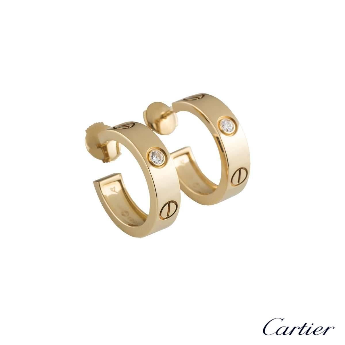 A pair of 18k yellow gold diamond earrings from the iconic Love collection by Cartier. Each hoop earring is set with 1 round brilliant cut diamond in a rubover setting, totalling 0.14ct. The earrings are 2 cm in length and 0.5cm in width and feature