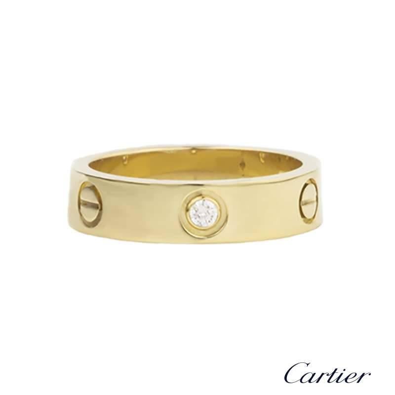 An iconic 18k yellow gold half diamond ring from the Love collection by Cartier. The ring comprises of 3 round brilliant cut diamonds in a rubover setting which alternate between the iconic screw motif through the centre of the band. The ring is a