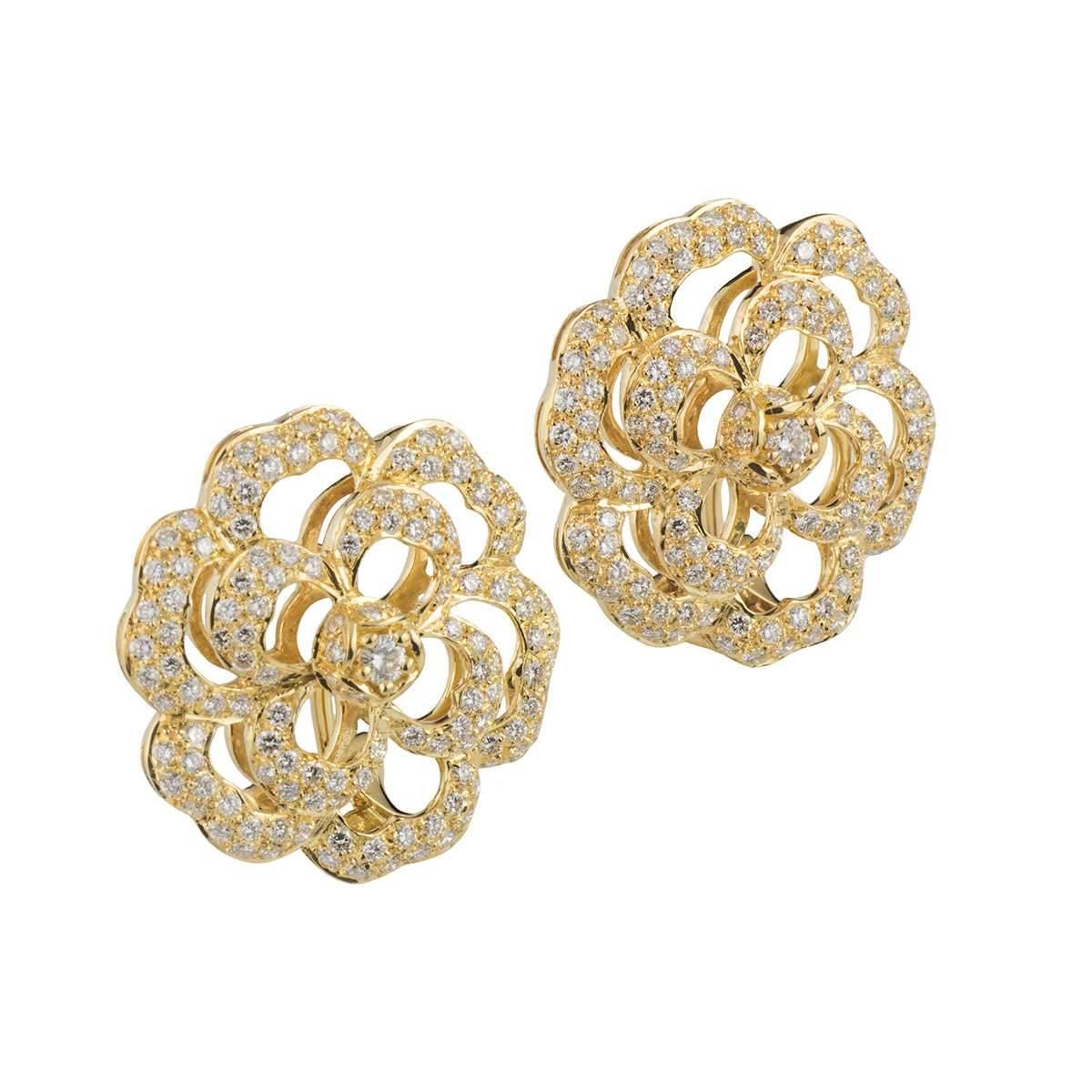 A sparkly pair of 18k yellow gold diamond earrings. The earrings comprise of an open work flower motif, each earring comprises of 127 round brilliant cut diamonds with a diamond in the centre. The diamonds have a total weight of 1.85ct, G colour and