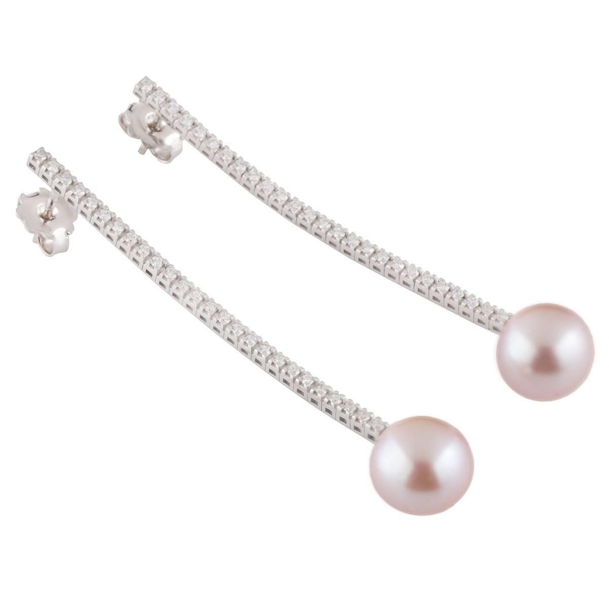 A beautiful 18k white gold diamond and pearl earrings. The earrings comprises of a line of round brilliant cut diamonds in 4 claw setting finished off with a pink pearl at the end. The diamonds have a total weight of 0.68ct, G colour and VS clarity.