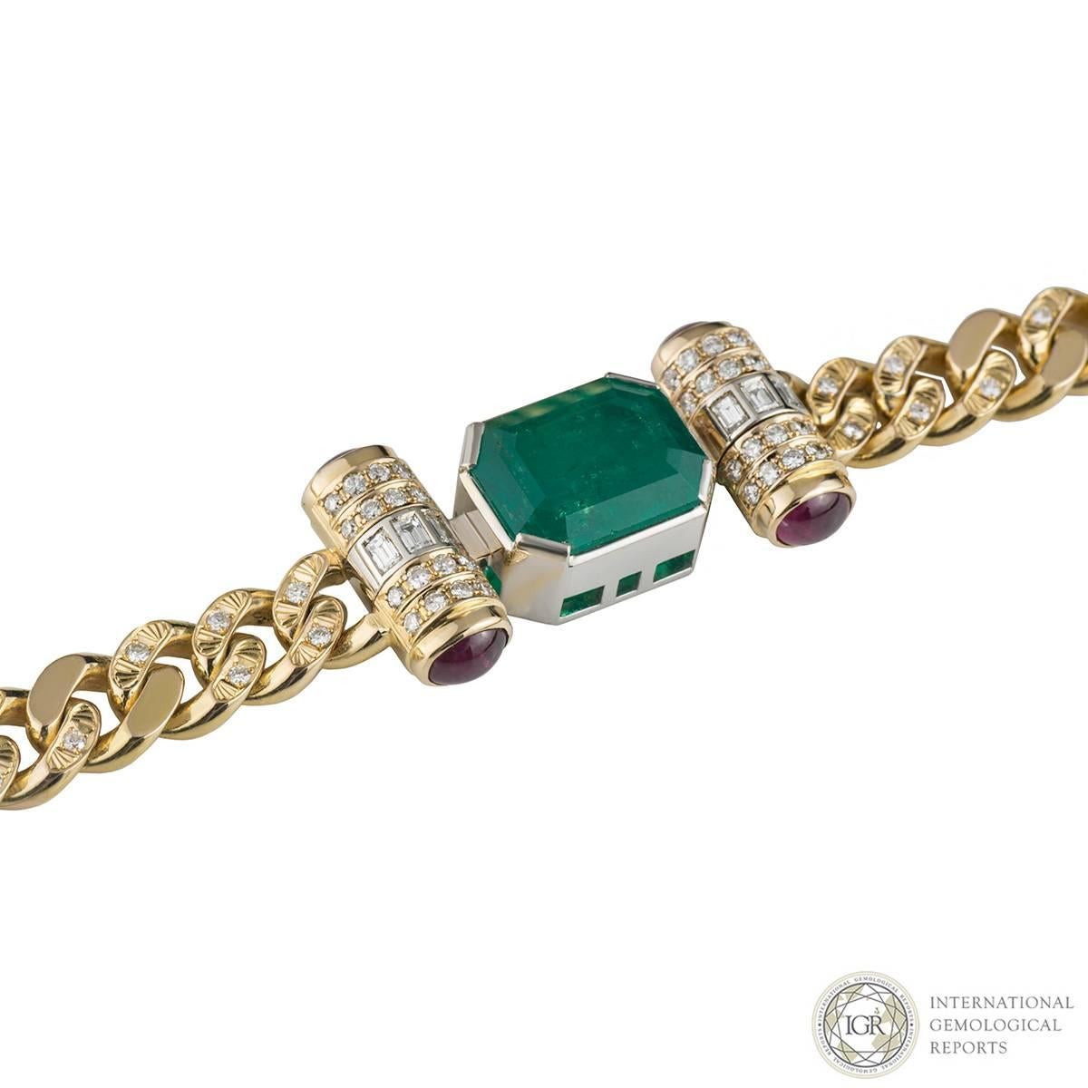 A lovely 18k yellow gold diamond, emerald and ruby necklace. The necklace comprises of an octagonal cut emerald gemstone with a total weight of 9.67ct, with a strong green colour and Type III SI clarity, in a rubover setting. Complementing the