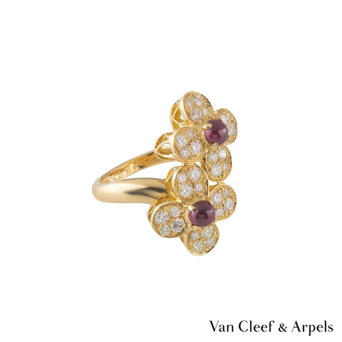 A beautiful 18k yellow gold Van Cleef & Arpels diamond and ruby ring from the Vintage Alhambra collection. The ring comprises of a double 4 petal flower motifs with a cabochon cut ruby in the centre of each. Complementing this motif are 4 round