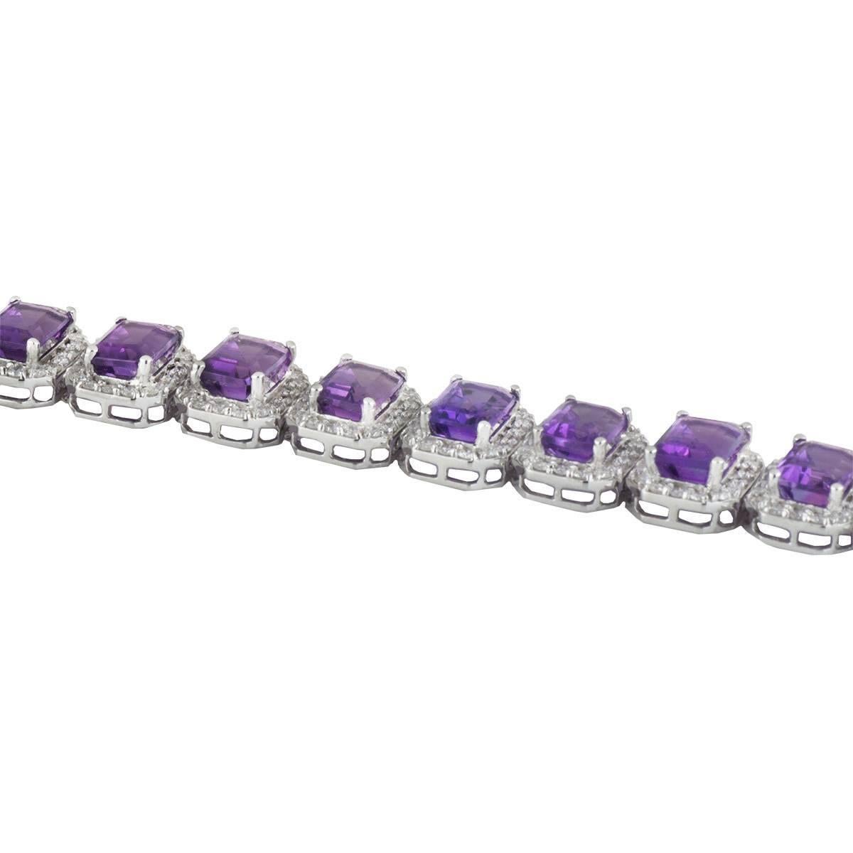 A lovely 18k white gold diamond and amethyst line bracelet. The bracelet comprises of 16 links of emerald cut peridots with a halo of round brilliant cut diamonds around each. There are 20 emerald cut amethysts with a total weight of 20.38ct with a