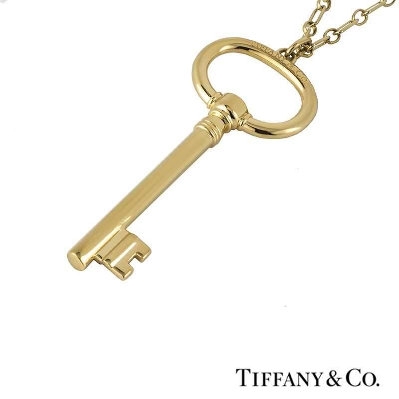 A signature 18k yellow gold key pendant and chain from the Tiffany & Co Tiffany keys collection. The iconic extra-large oval key pendant features the Tiffany & Co signature across the barrel of the key and also on the reverse side of the oval top.