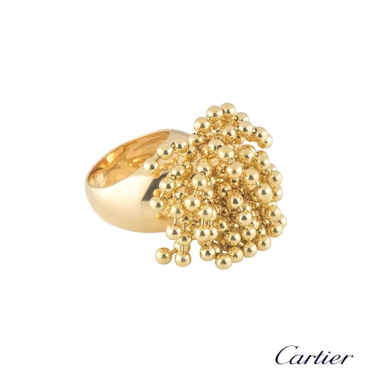 A unique 18k yellow gold ring by Cartier from the Paris Nouvelle Vague collection. The ring features a cluster of flexible bead tassels dispersing from the top over the finger. The ring measures 1.5cm in height and approximately 3cm in width. The