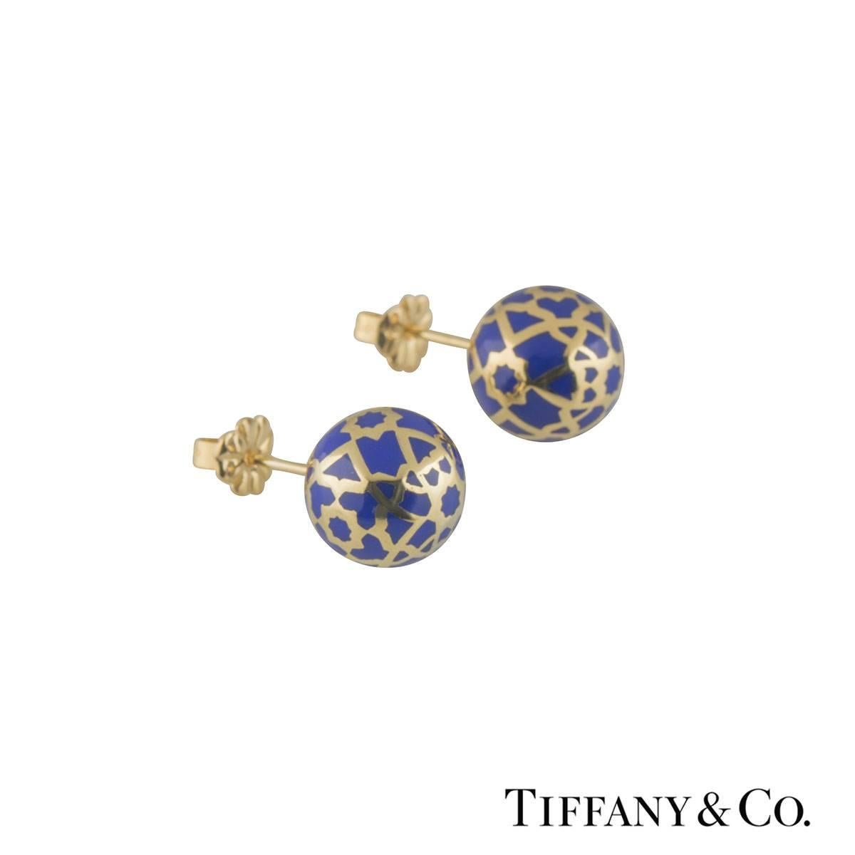 A trendy 18k yellow gold Tiffany & Co. stud earrings. The earrings comprise of a gold ball with blue enamel patterned throughout the ball. The earring measures 12mm in diameter and features a post and push back butterfly. The earrings have a