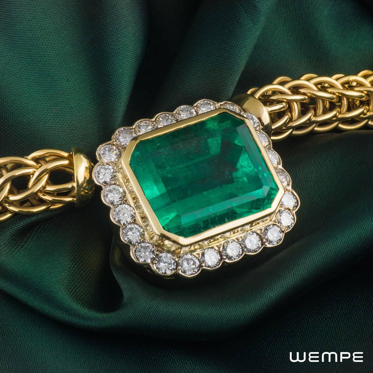 An exquisite 18k yellow gold emerald and diamond necklace by Wempe. The necklace is set to the front with a natural Columbian emerald weighing approximately 40.00ct, displaying a rich even colour and has a diamond surround. The 24 round brilliant