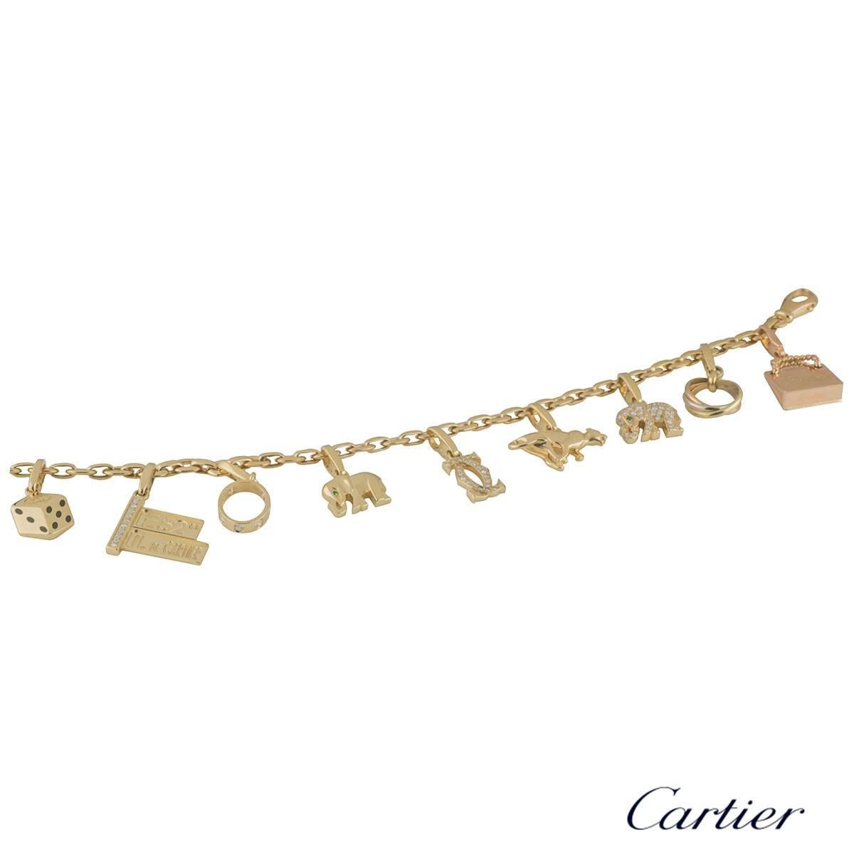 A unique 18k yellow gold Cartier charm bracelet. The bracelet comprises of a yellow gold flat cable chain with 9 Cartier charms. The first charm is a mini Trinity de Cartier ring in tri colour gold. The second charm is a rose gold Cartier bag with