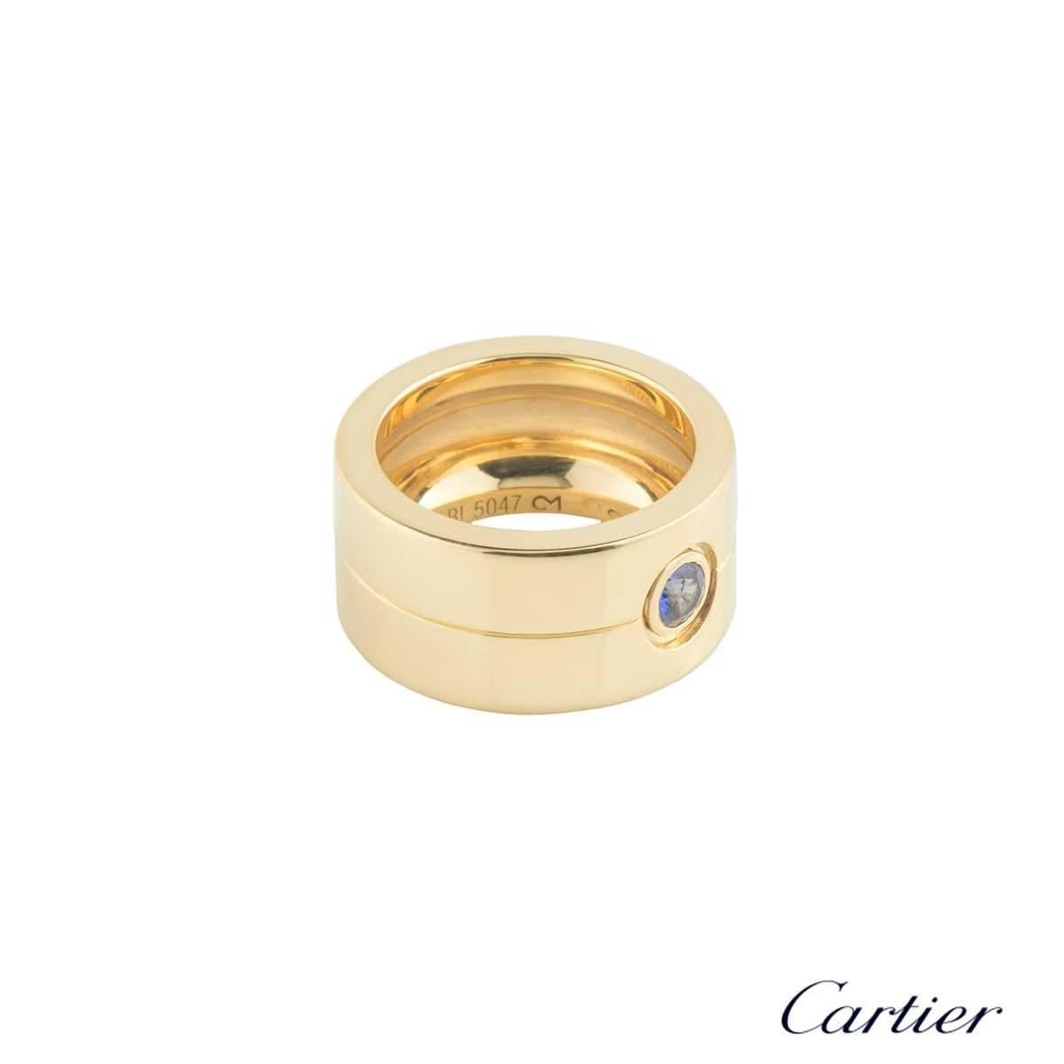 An 18k yellow gold and sapphire Cartier dress ring. The ring comprises of a round brilliant cut sapphire in a rubover setting weighing 0.25ct, with a blue hue throughout. The ring is a US size 6 3/4, EU size 54 and UK size N1/2 and measures 10mm in