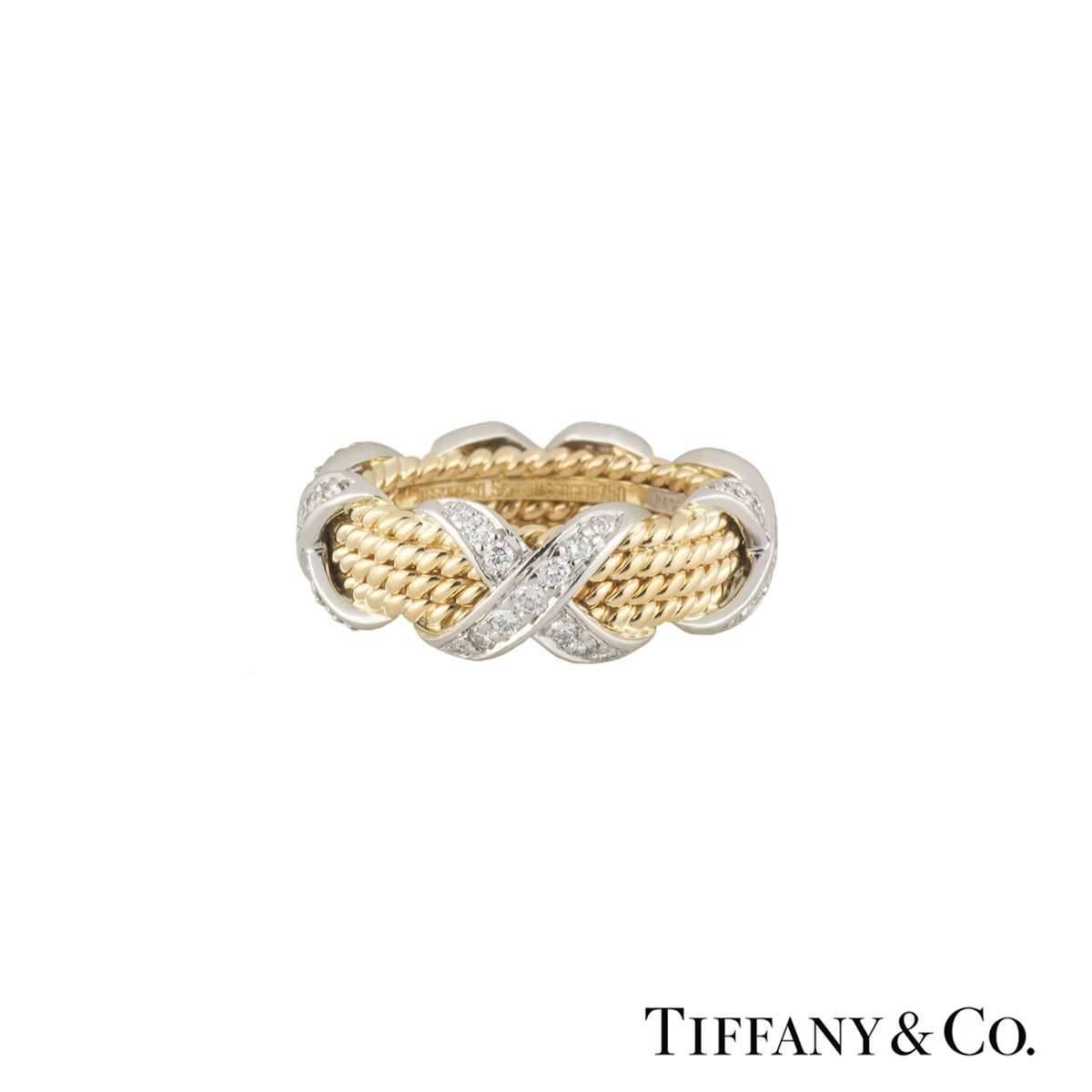 An 18k yellow gold and platinum Rope Four-Row Schlumberger ring by Tiffany & Co. The rope design ring features 4 signature 'X' motifs pave set with round brilliant cut diamonds totalling 0.54ct. The 8mm wide ring is a US size 6, EU size 52 and