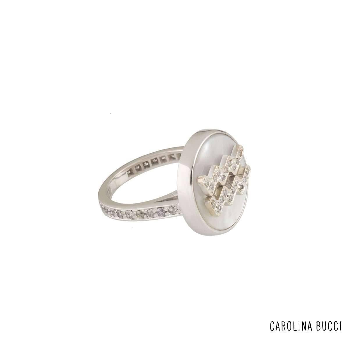 A unique 18k white gold diamond and mother of pearl Carolina Bucci ring from the Lucky Zodiac collection. The ring comprises of a circular motif with a mother of pearl inlay in a rubover setting. Complementing this motif is the aquarius zodiac sign