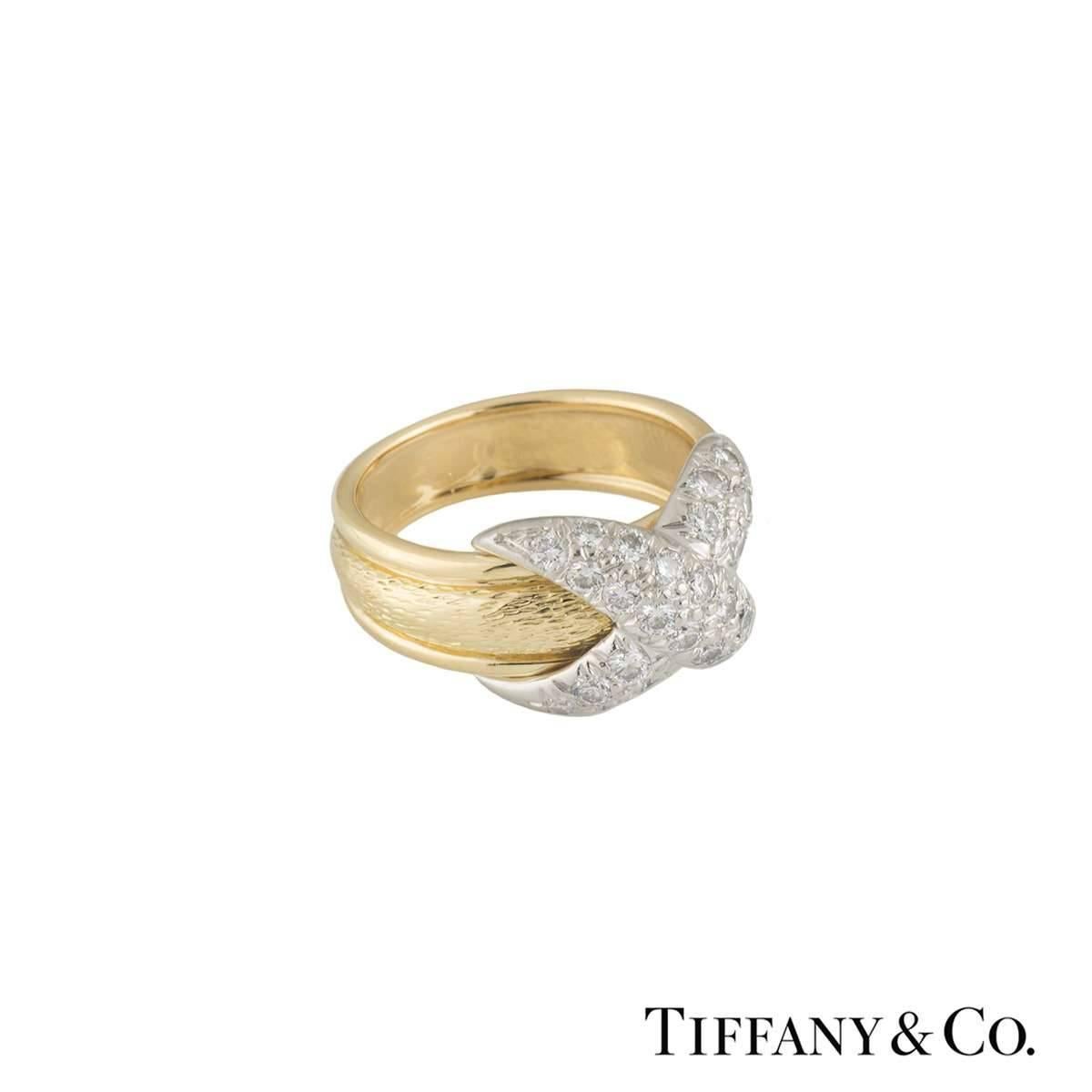 A lovely 18k yellow gold and platinum Tiffany & Co. diamond dress ring from the Schlumberger collection. The ring comprises of a 5mm patterned band with the classic Schlumberger cross motif placed in the centre encrusted with round brilliant cut