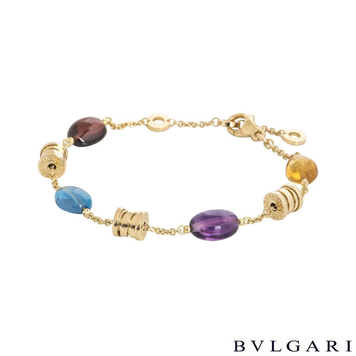 An 18k yellow gold multi-gem bracelet by Bvlgari from the B.zero1 collection. The bracelet comprises of a single amethyst, blue topaz, citrine and garnet alternating with the 'Bvlgari Bvlgari' barrels. The amethyst has a weight of 0.75ct, blue topaz