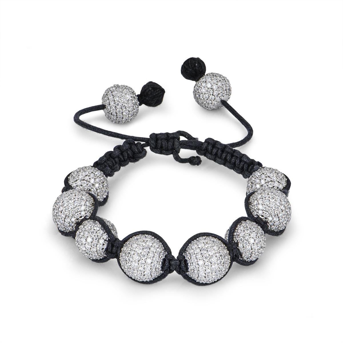 An exquisite 18k white gold pave diamond set cord bracelet. The bracelet is composed of 8 large beads interlinked by a black adjustable woven cord, completed by two smaller beads to adjust the cord for a perfect fit. Each bead is intricately set