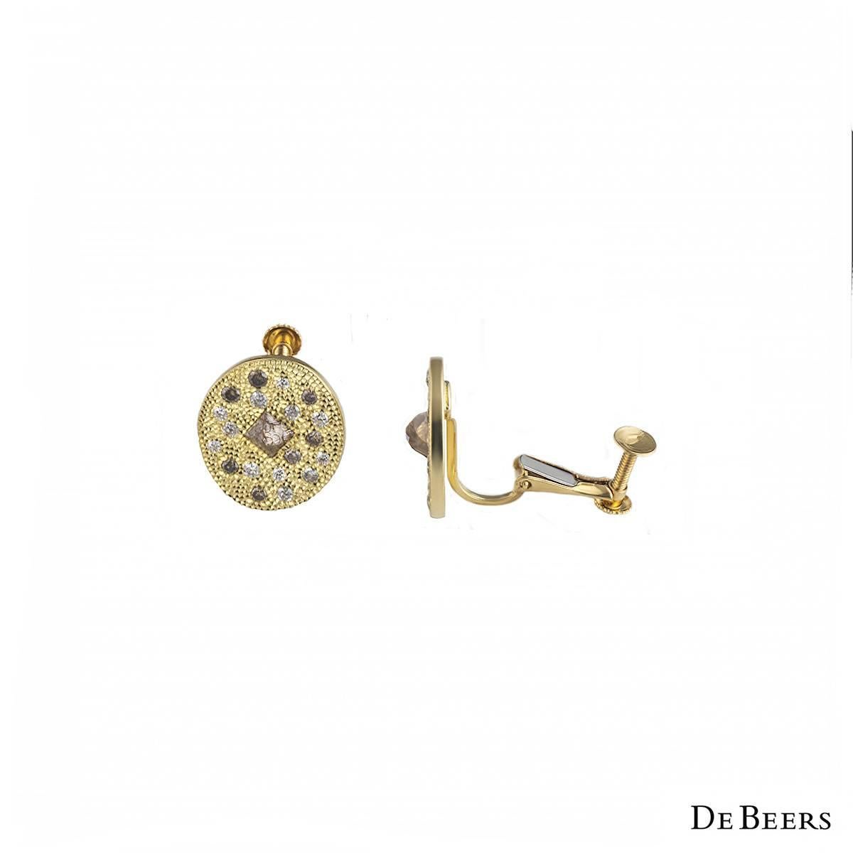 A unique pair of 18k yellow gold earrings from the Talisman collection by De Beers. The earrings are of an oval design and are composed of both polished and rough diamonds, varying in colour from white to brownish pink tones. The earrings measure