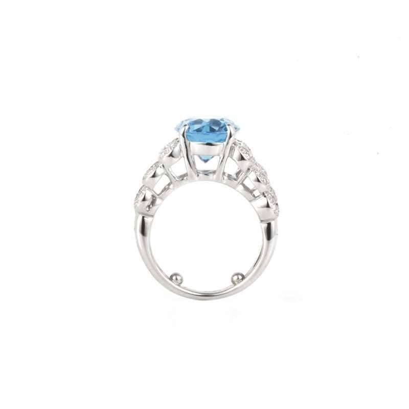 An 18k white gold diamond and blue Topaz dress ring. The central stone is a beautiful oval shape blue Topaz  weighing approximately 5.40ct which is complimented by pave set diamond shoulders in multiple figure of 8 designs. The 58 round brilliant
