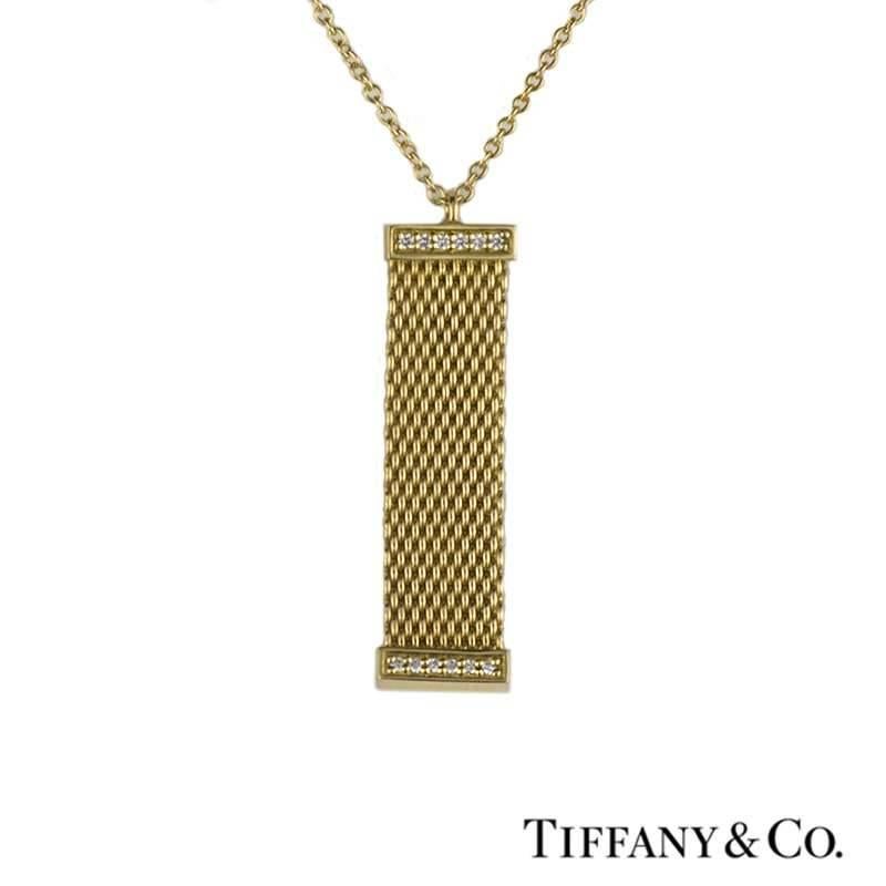 A beautiful 18k yellow gold 4 piece suite from the Mesh collection by Tiffany & Co. The suite comprises of a solid 3mm mesh circular bangle and matching hoop earrings with post and butterfly fittings. This is then complemented by a pave diamond set