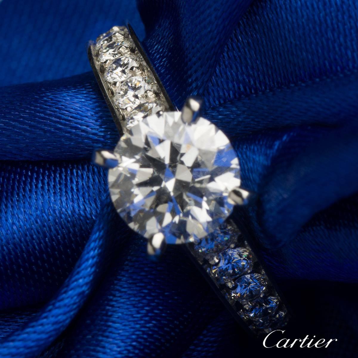A stunning round brilliant cut diamond ring from the 1895 collection by Cartier. The ring is set to the centre with a 1.52ct round brilliant cut diamond, G colour and VVS2 in clarity. Accentuating the central diamond are half pave set diamond