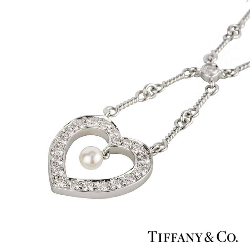 An elegant diamond and pearl necklace in platinum by Tiffany & Co. The necklace is set with a single round brilliant cut diamond leading on to an open work heart motif, pave set with 20 round brilliant cut diamonds totalling approximately 1.00ct.