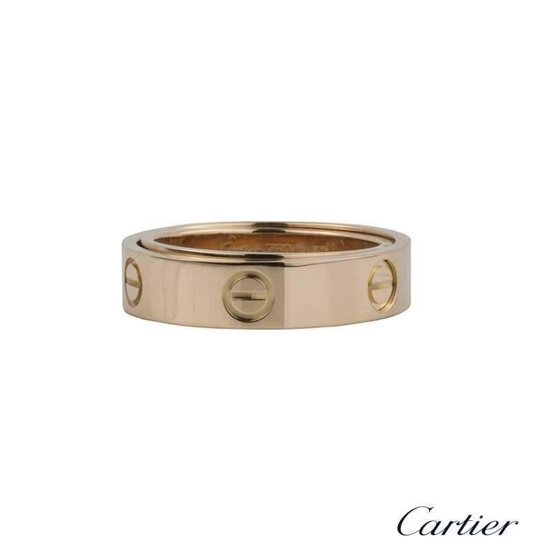 An 18k rose gold Spicy Love ring by Cartier. The ring is of a polished finish and displays the iconic 6 screw motif around the outside of the ring. The ring is made up of 2 rings that pivot on hinges, creating a 3D ball design. The ring is a US size