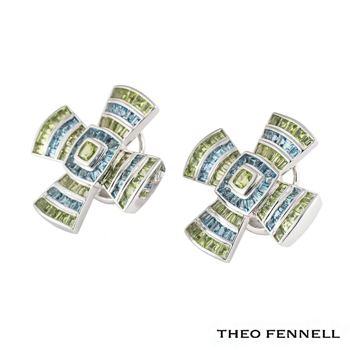 A Theo Fennell 18k white gold cross earrings. This pair of earrings is a byzantine style cross set with multi-gemstones. There are 36 blue topaz and 41 peridot gemstones totalling approximately 3.41ct. The earrings measure 3cm in height and 3cm in