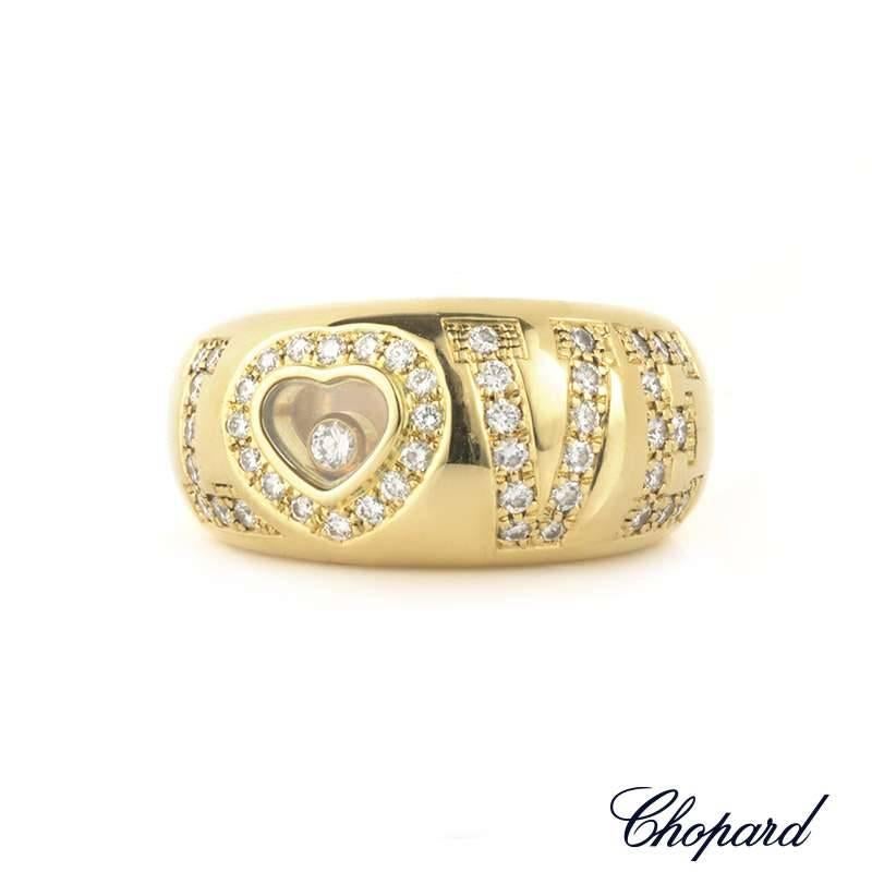 An 18k yellow gold Chopard 'Love' ring from the Happy Diamonds collection. The centre half of the ring is set with the word LOVE, of which each letter is individually set with pave set round brilliant cut diamonds totalling 0.52ct G+/VS+. The letter