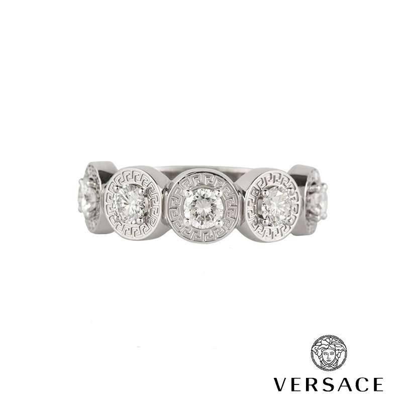 US size 8 5/8.  An 18k white gold diamond set dress ring by Versace. The ring is set with five circular motifs each engraved around the outer edge with the iconic Versace logo and set to the centre with a 0.20ct round brilliant cut diamond, G/H in