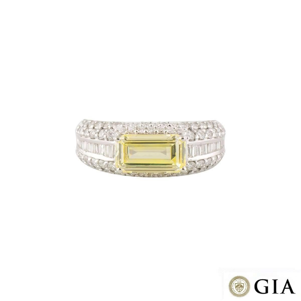 A luxurious 18k white gold diamond engagement ring. The ring comprises of a emerald cut fancy intense yellow diamond with a total weight of 2.01ct and VVS2 clarity. The diamond is complimented with 14 baguette cut diamonds in a tension setting
