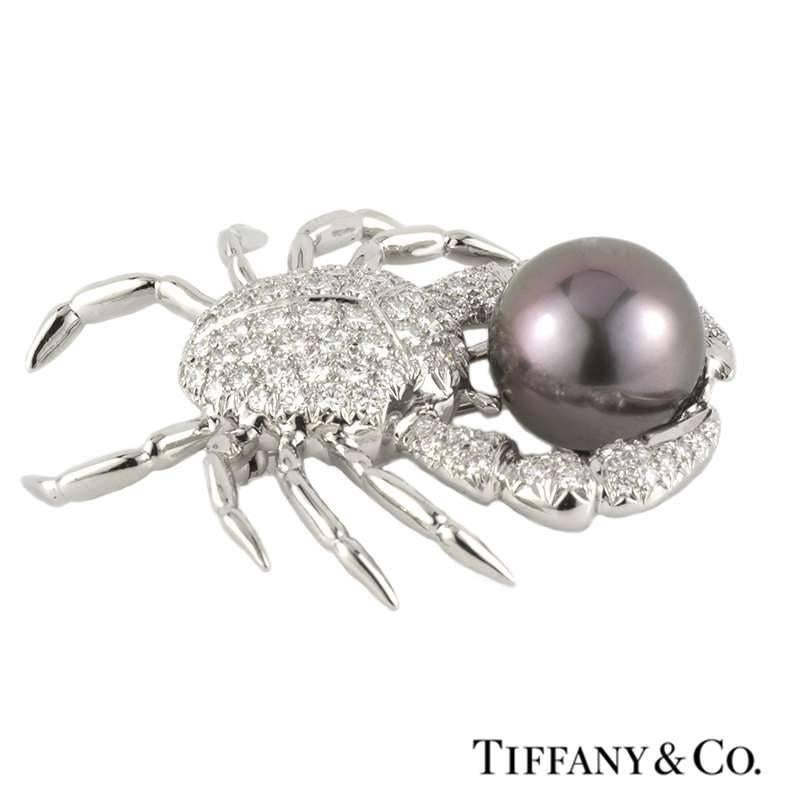 An exquisite diamond and pearl crab brooch in platinum by Tiffany & Co. The open work crab brooch is comprised of round brilliant cut diamonds pave set throughout the body and claws totalling approximately 2.70ct, predominantly G colour and VS