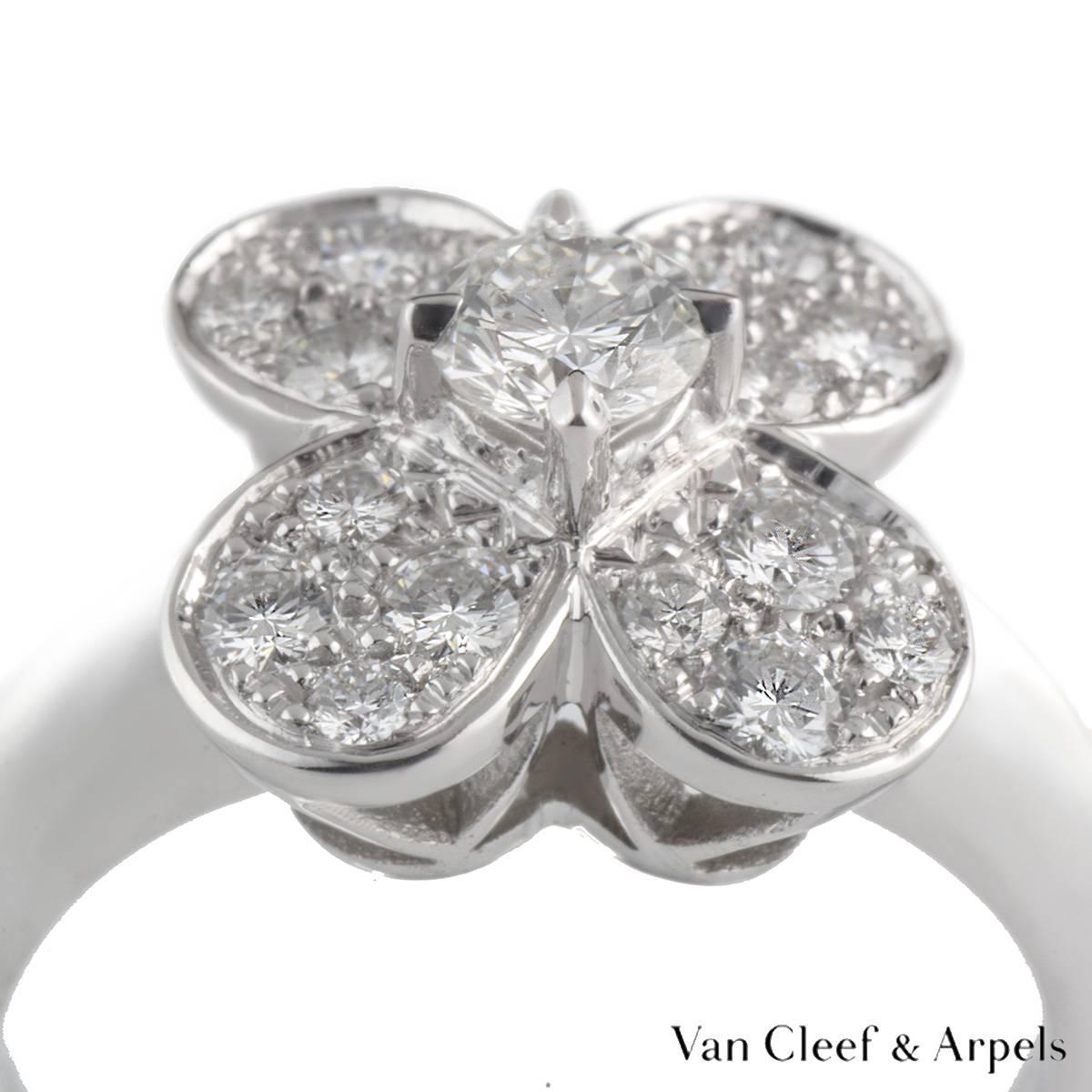 A brilliant 18k white gold Alhambra ring by Van Cleef & Arples. The central flower motif is set with a single claw set round brilliant cut diamond weighing approximately 0.35ct. The petals of the flower are pave set with round brilliant cut diamonds